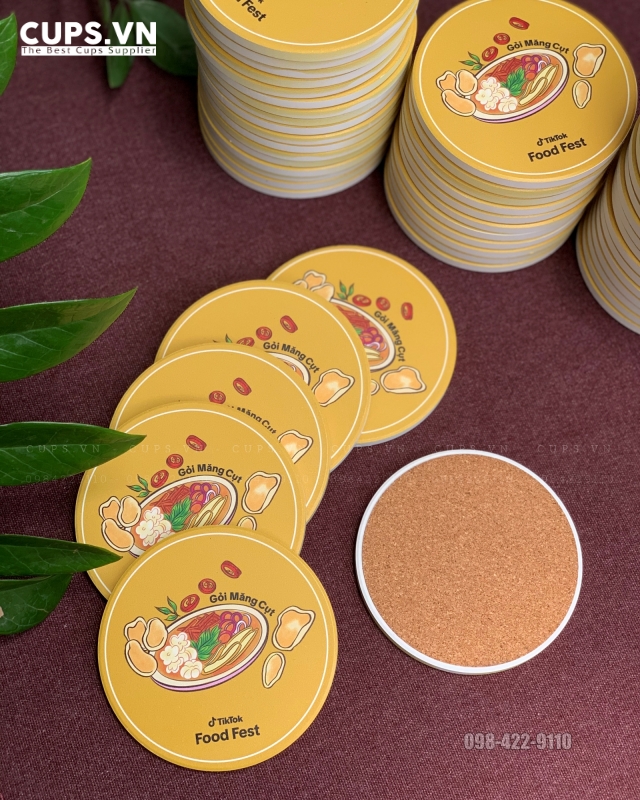 Lót ly gốm sứ có đế gỗ (thường là gỗ bần hoặc mụn cưa nén) là sự kết hợp hoàn hảo giữa khả năng thấm hút nước nhanh của gốm ceramic và độ bám vững chắc của đế gỗ, giúp bảo vệ mặt bàn khô ráo, không bị trầy xước hay trơn trượt