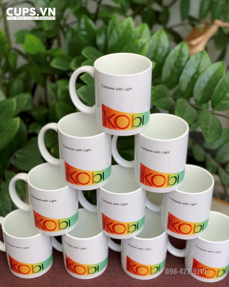 Ly sứ trắng in logo nhiều màu trải quanh ly